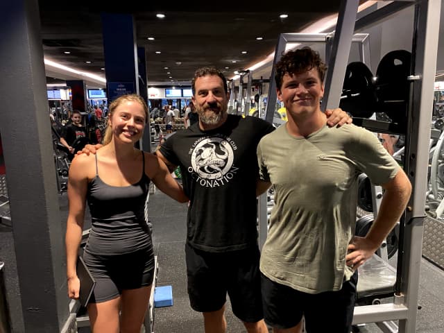 a photo of millie and alex with andrew huberman at the gym